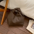 Dettaglio della pelle martellata marrone scuro di una borsa a spalla a mezzaluna con nodo - Marrone