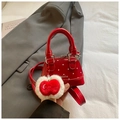 Red polka dot mini handbag with apple charm and shiny finish on a grey blazer background - Small / Red