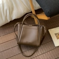 Dark brown lychee pattern leather bucket bag with shoulder strap in a cozy home setting - No Pendant / Brown