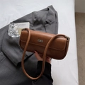 Nahaufnahme einer braunen Leder-Achseltasche mit Metall-Logo und schickem Schulterriemen - Braun