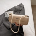 Detail der minimalistischen beigen Achseltasche mit silbernem Logo und Lederstruktur - Sojaweiß