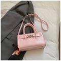 Sac bandoulière en cuir rose avec boucles argentées et deux poignées sur un blazer - Rose