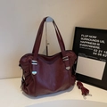 Detalle del bolso tote burdeos en cuero sintético con textura fina y hebillas metálicas - Rojo