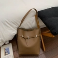 Close-up of brown litchi pattern leather texture and silver buckle on bucket bag - Brown