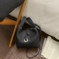 Close-up of black lychee grain leather bucket bag with silver metal ring and strap - Black