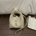 Close-up of cream lychee grain leather bucket bag with silver metal ring detail - White