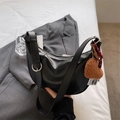 Borsa a spalla a mezza luna nera in pelle liscia con ciondolo a forma di cuore in peluche - Nero con ciondolo