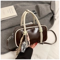 Nahaufnahme einer braunen Boston-Tasche mit hellen Griffen und Designer-Anhängern - Kaffee (Mit Anhänger)