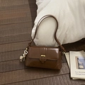 Detail of vintage brown leather underarm bag with metal clasp and white flower charm - Brown with Pendant