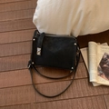 Flat lay of vintage black square bag with silver ring clasp on a lifestyle background - Black
