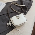 Creamy white leather saddle bag with star charm and brown trim on grey blazer - White with Pendant