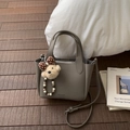 Detail of grey lychee leather tote bag with bear charm and adjustable shoulder strap - Gray With Pendant