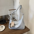 Detail of light blue crescent tote with soft leather texture and plush alpaca charm - Blue with Charm