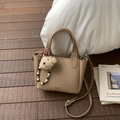 Close-up of brown litchi pattern leather handbag with cute teddy bear charm and logo detail - Khaki with Pendant