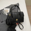 Classic black leather handbag with gold buckle and adjustable strap on a white background - Black