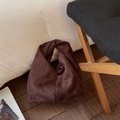 Close-up of dark brown suede cloud bag showing knotted handle and textured fabric - Brown