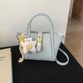 Dettaglio mini borsa azzurra in pelle martellata con chiusura dorata e ciondolo a orso - Con Ciondolo / Blu