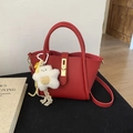 Dettaglio della borsa in pelle martellata rossa con chiusura dorata e ciondolo - Con Ciondolo / Rosso