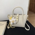 Detail of cream-white lychee texture leather bag with star charm and gold twist lock - With Charm / Off White