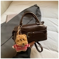Close-up of dark brown faux leather bag with stylish buckle and cute dog charm - With Charm / Coffee