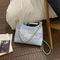 Dettaglio della borsa a tracolla azzurra con catena dorata e logo a doppio anello - Blu