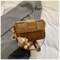 Chic brown woven PU leather crossbody bag with a fuzzy monster charm and metal chain - Brown