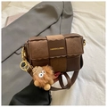 Brown patchwork woven crossbody bag with plush monster charm and golden hardware detail - Brown