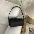 Détail du sac Boston noir en cuir grainé avec fermeture éclair argentée sur un canapé - Noir
