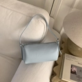 Vue détaillée de la texture de cuir litchi bleu clair sur un mini sac Boston - Bleu