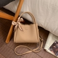 Close-up of beige lychee grain leather tote bag with silk scarf detail and brand logo - Khaki