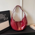 Detailed close-up of dark red patent leather hobo bag with pleated texture and silver hardware - Burgundy