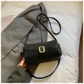 Minimalist black square crossbody bag with gold buckle on a stylish suit backdrop - Black