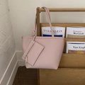 Close-up of pink leather tote bag featuring a knotted strap and a small coin purse - Pink