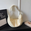 Detail view of cream crescent hobo bag in glossy leather with silver zipper and strap - Yellow