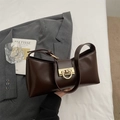 Dettaglio della borsa sottobraccio in pelle testa di moro con chiusura dorata e finitura lucida - Marrone