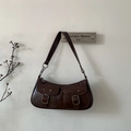 Primo piano della borsa a tracolla vintage marrone scuro con fibbie in metallo decorative - Marrone