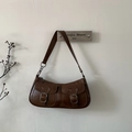 Close-up of a vintage dark brown leather shoulder bag with buckle pockets and worn texture - Brown