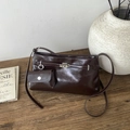 Makroaufnahme einer braunen Vintage-Tasche mit Silberverschluss und kleiner Tasche - Kaffeebraun