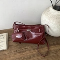 Dettaglio borsa a spalla in pelle bordeaux con chiusura a scatto in argento su legno - Rosso Angola