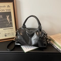 Bolso Boston minimalista en cuero negro brillante con correa ajustable y adorno colgante - Negro
