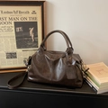 Bolso Boston clásico en color marrón oscuro de cuero texturizado con detalles dorados - café