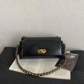 Details einer glänzenden schwarzen Ledertasche mit goldenem Drehverschluss und Kette - Schwarz