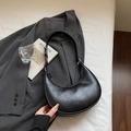 Fashionable black matte leather hobo underarm bag with silver hardware on a book - Black