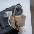 Vintage Beuteltasche in Creme mit Knotengriff und Perlenanhänger auf grauem Blazer - Reisweiß (Mit Anhänger)