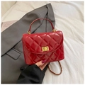 Rote Stepptasche mit goldener Kette und Drehverschluss auf einem grauen Anzug Hintergrund - Rot