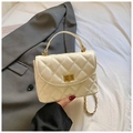 Schicke cremefarbene Stepptasche mit Goldschließe und Kettenriemen auf Blazer - Weiß