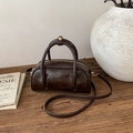 Deep brown vintage leather pillow bag with dual handles and gold zippers on a wood table - No Pendant / Brown