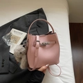 Pink lychee grain leather bucket bag featuring a plush charm and silver metal lock detail - Pink