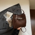 Dunkelbraune Eimer-Tasche aus Narbenleder mit Metallschnalle und Plüschhasen-Anhänger - Braun