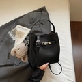 Detail der schwarzen Leder-Beuteltasche mit silbernen Beschlägen und Plüsch-Hasenanhänger - Schwarz